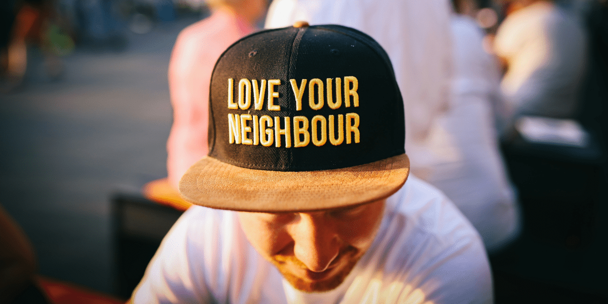 man with a hat stating "love your neighbor"